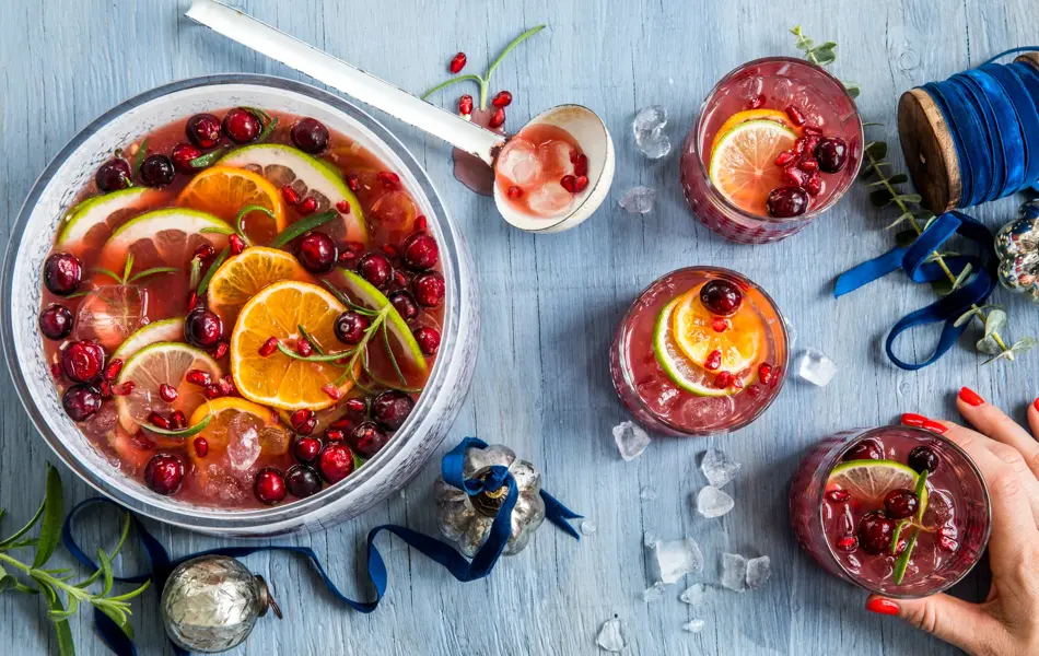 Rød julepunch i en bolle og tre glass.