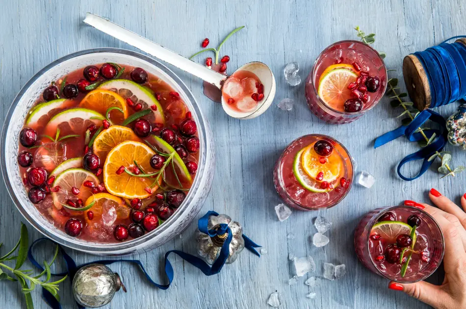 Rød julepunch i en bolle og tre glass.