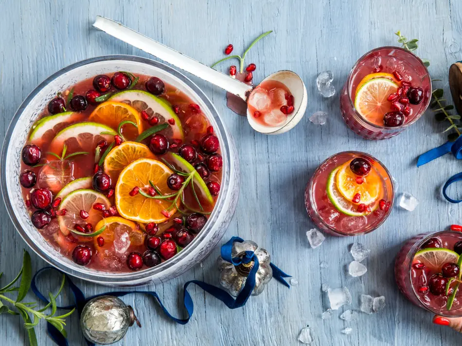 Rød julepunch i en bolle og tre glass.