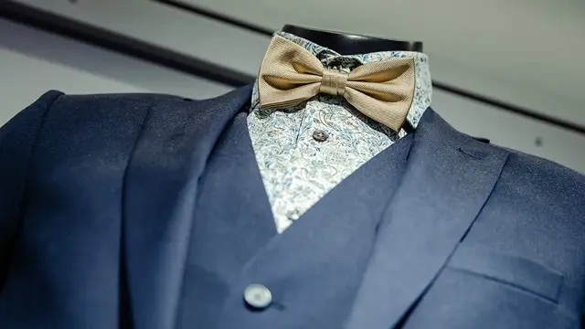 Bilde av blå dressjakke, vest, skjorte og sløyfe