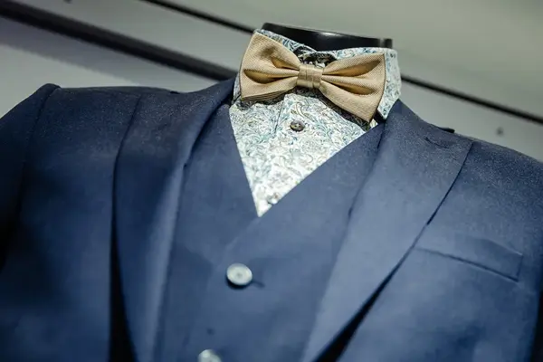 Bilde av blå dressjakke, vest, skjorte og sløyfe
