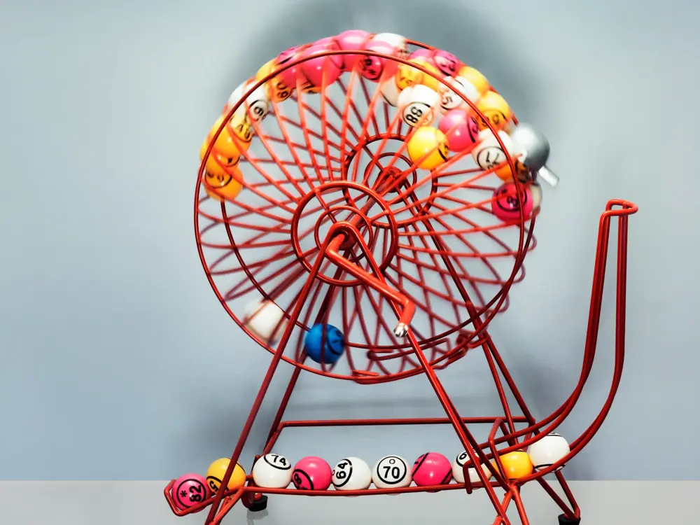 A bingo machine front on contains bingo balls  moving excitingly around
