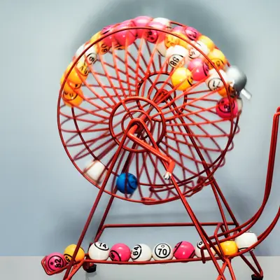 A bingo machine front on contains bingo balls  moving excitingly around