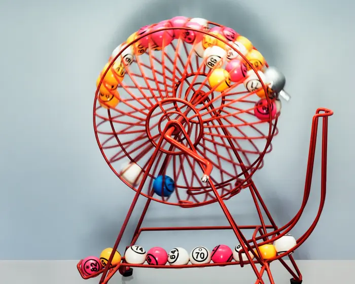 A bingo machine front on contains bingo balls  moving excitingly around