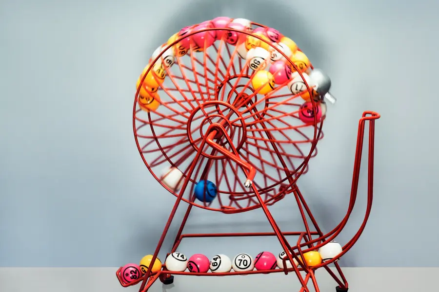 A bingo machine front on contains bingo balls  moving excitingly around