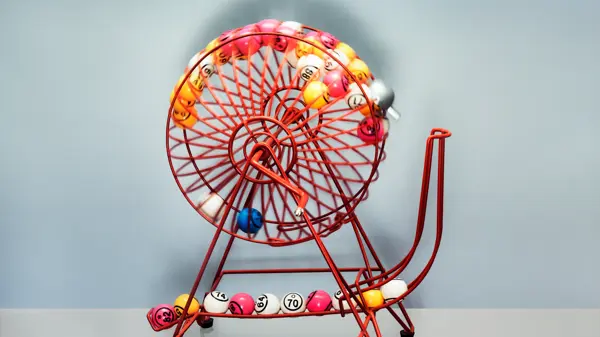 A bingo machine front on contains bingo balls  moving excitingly around