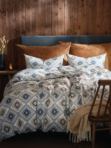 Seng med mønster sengesett og trevegg