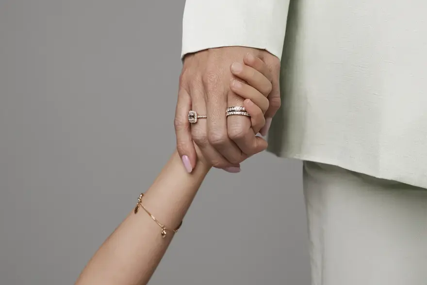 Barn og voksen som holder hender