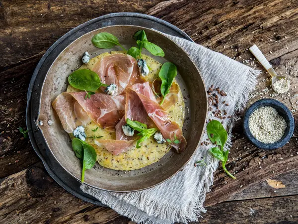 Tallerken med omelett og serranoskinke med ruccola