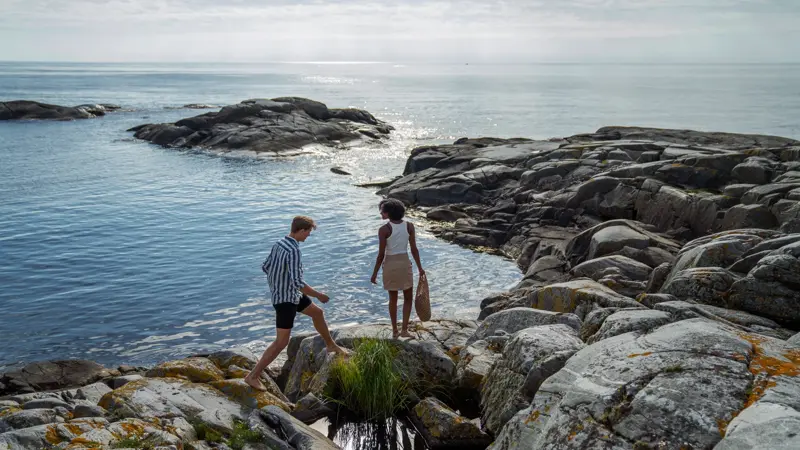 Et kjærestepar går langs skjærgården på sørlandet.