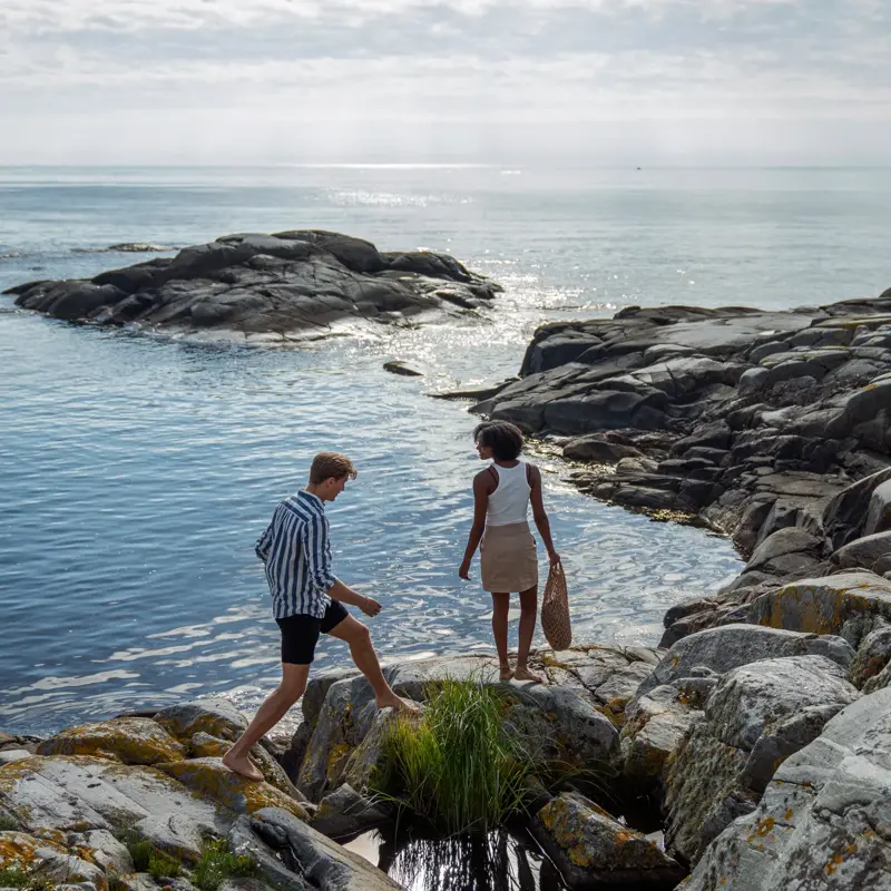 Et kjærestepar går langs skjærgården på sørlandet.