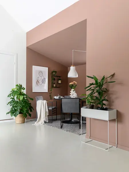 Brunt stuekrok med grønne planter og stol- og bord-gruppe