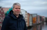 Trond Are Martinsen på Gamle Bybro med bryggerekka inkl. Kjøpmannsgata 15 i bakgrunnen. Trondheim.