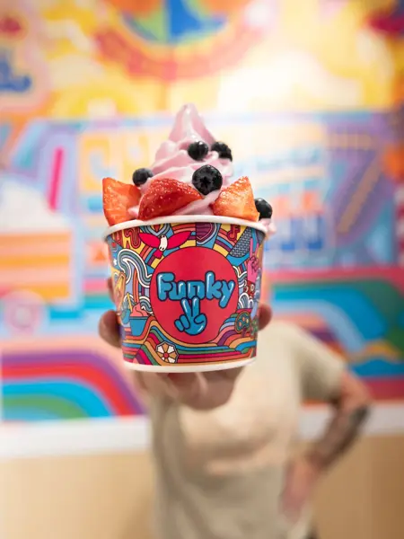 En perons holder fre met beger med Yogurtis