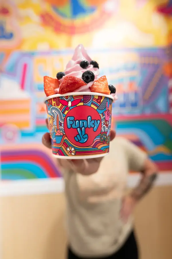 En perons holder fre met beger med Yogurtis