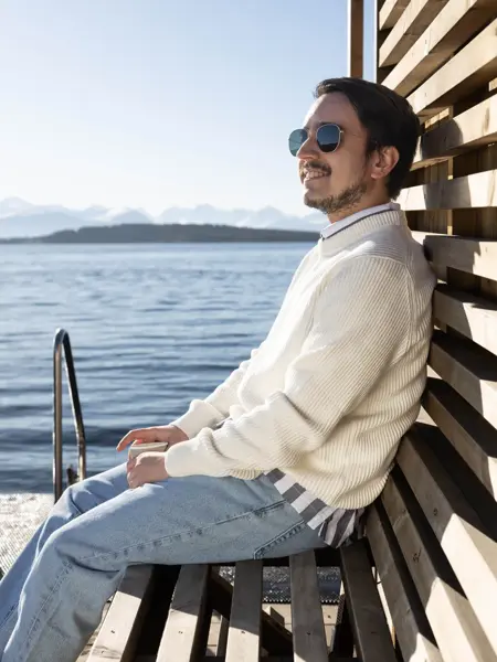 Mann som sitter ved vannkanten