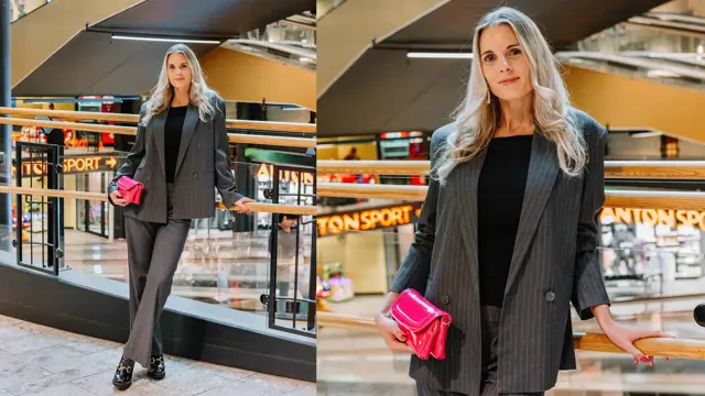 Dame med grå dress, rosa veske og svarte sko