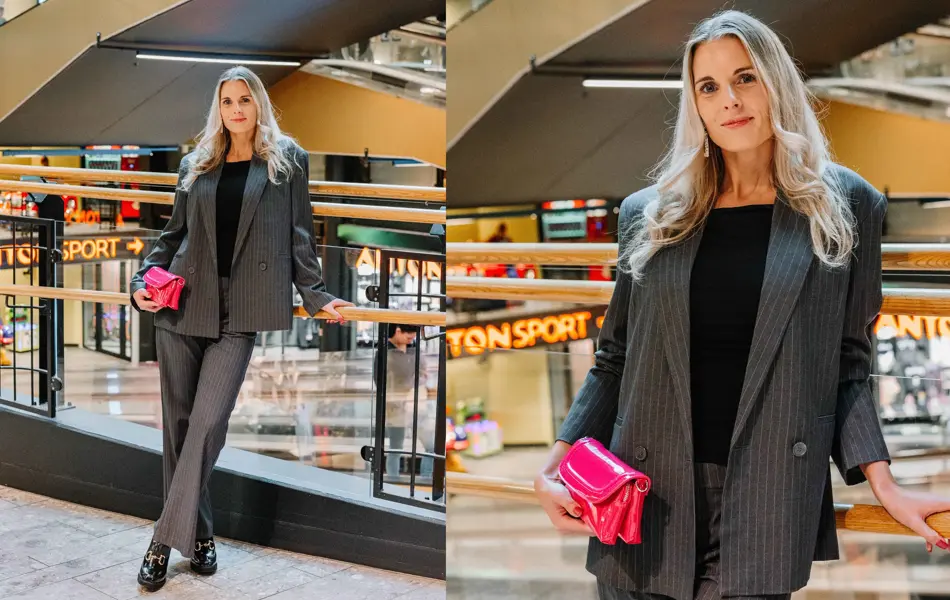 Dame med grå dress, rosa veske og svarte sko