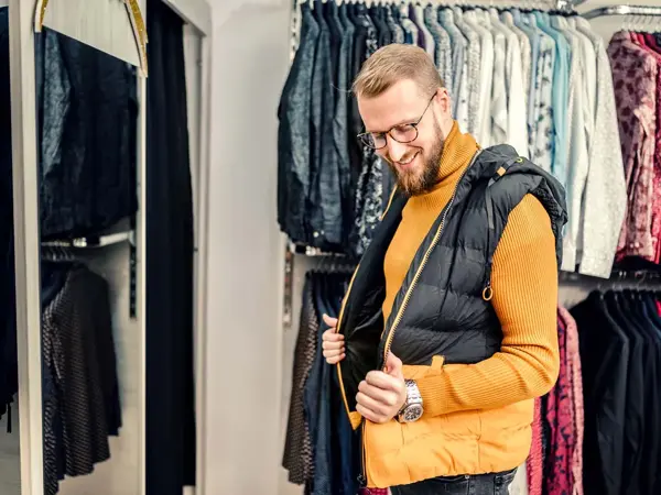 Mann prøver en boblevest i en klesbutikk.
