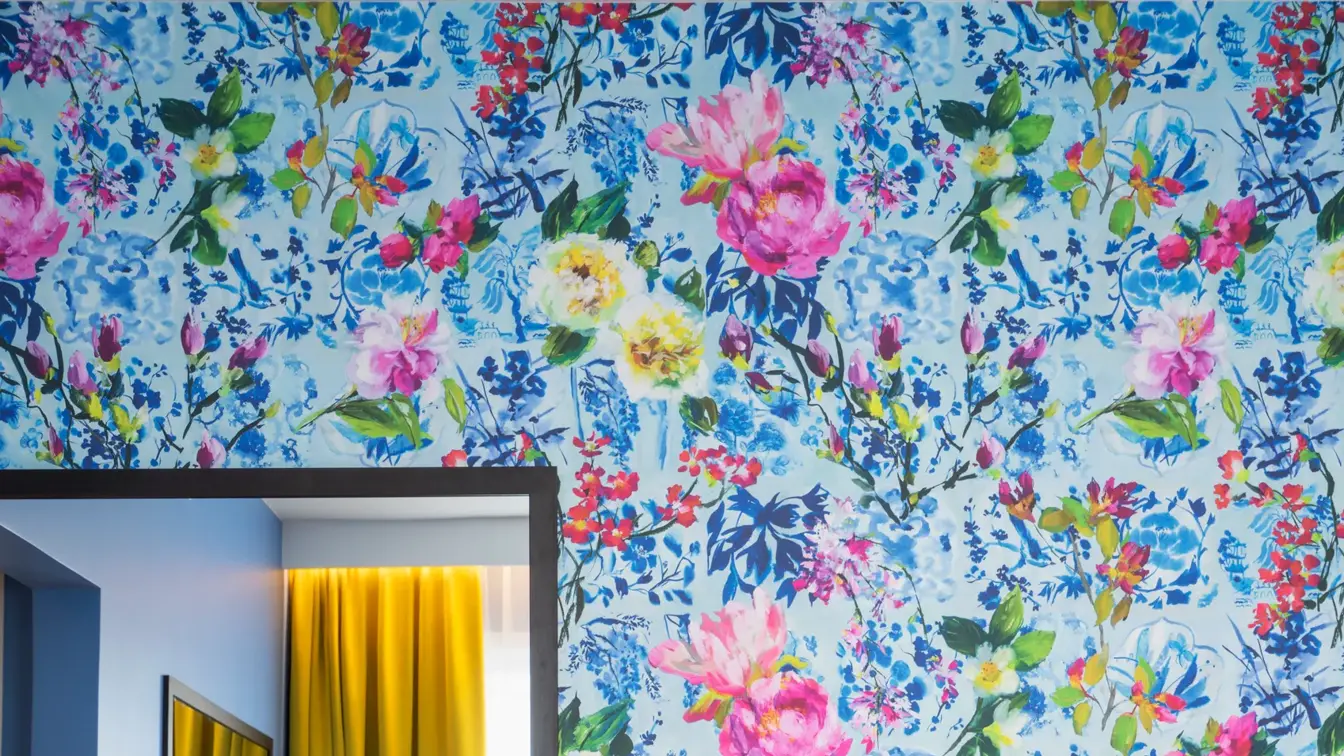 Skrivebord, speil, seng og blomstrete tapet  i business rom på Thon Hotel Moldefjord