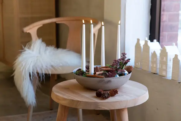 Sofabord med adventslysestake formet som en bolle fyllt med svibel og kanelstenger