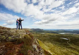 Mann og dame på fjelltur og peker utover naturen på Skeikampen. Foto.