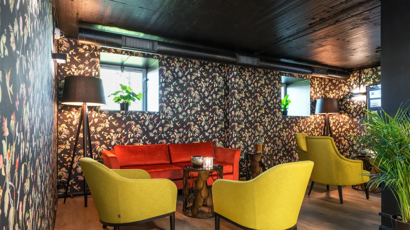 To gule lenestoler og en rød sofa i lobbyen på Thon Hotel Linne