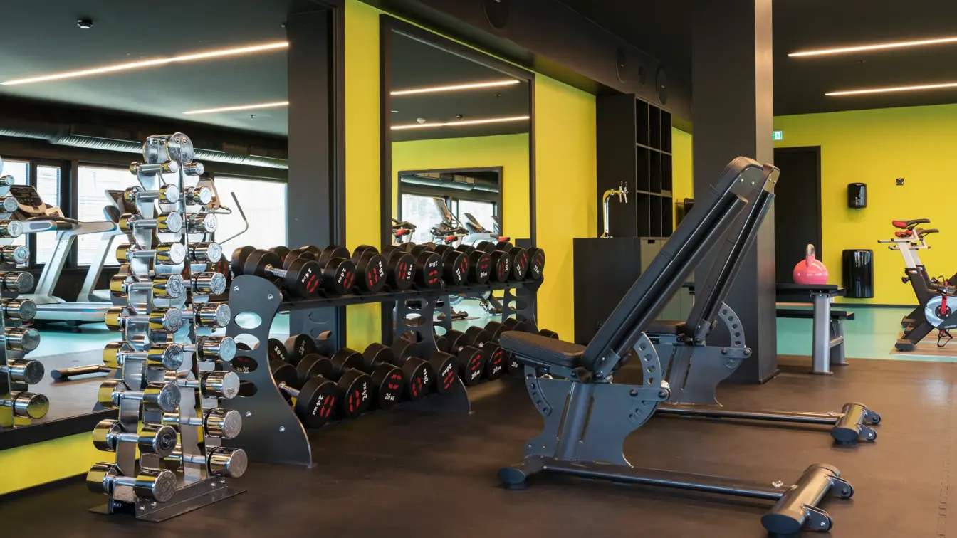 Treningsrom med vekter med gul og grønne farger på vegg og gulv på Thon Hotel Oslo Airport
