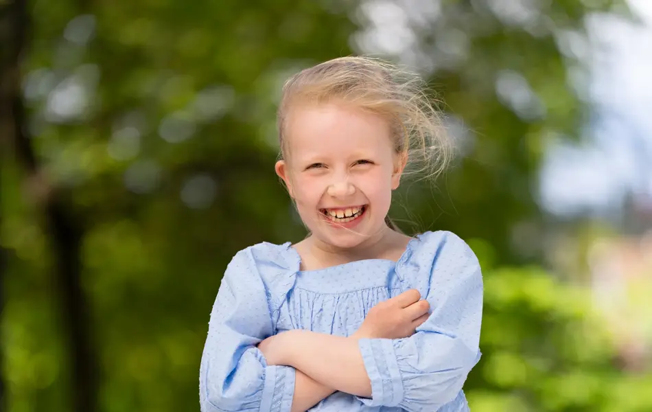 Jente står ute i lyseblå kjole