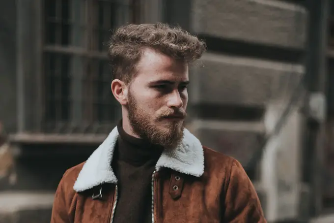 Mann i gata med brun jakke