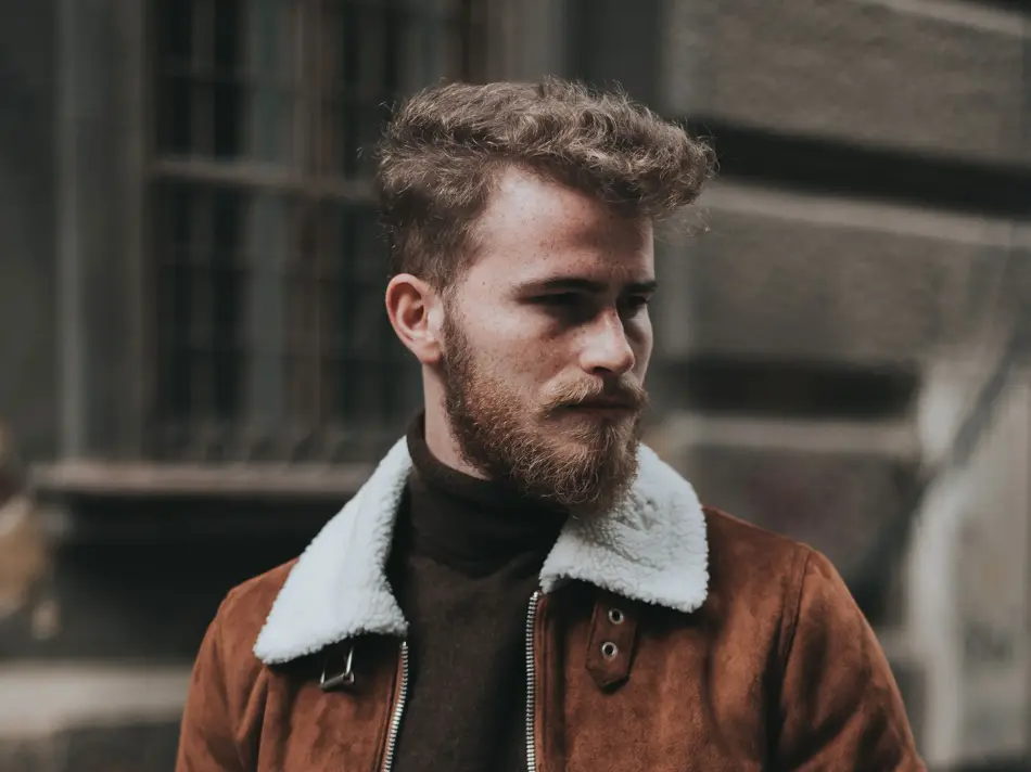 Mann i gata med brun jakke