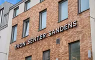 Thon Senter Sandens fasade, med logo skilt på veggen.