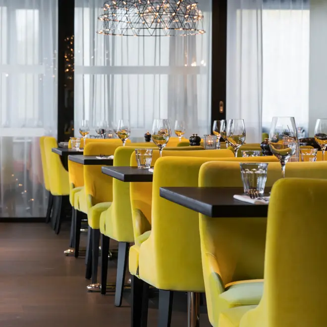 Frokostsal med gule og orange stoler ved dekket bord på Thon Hotel Oslo Airport ved Gardermoen