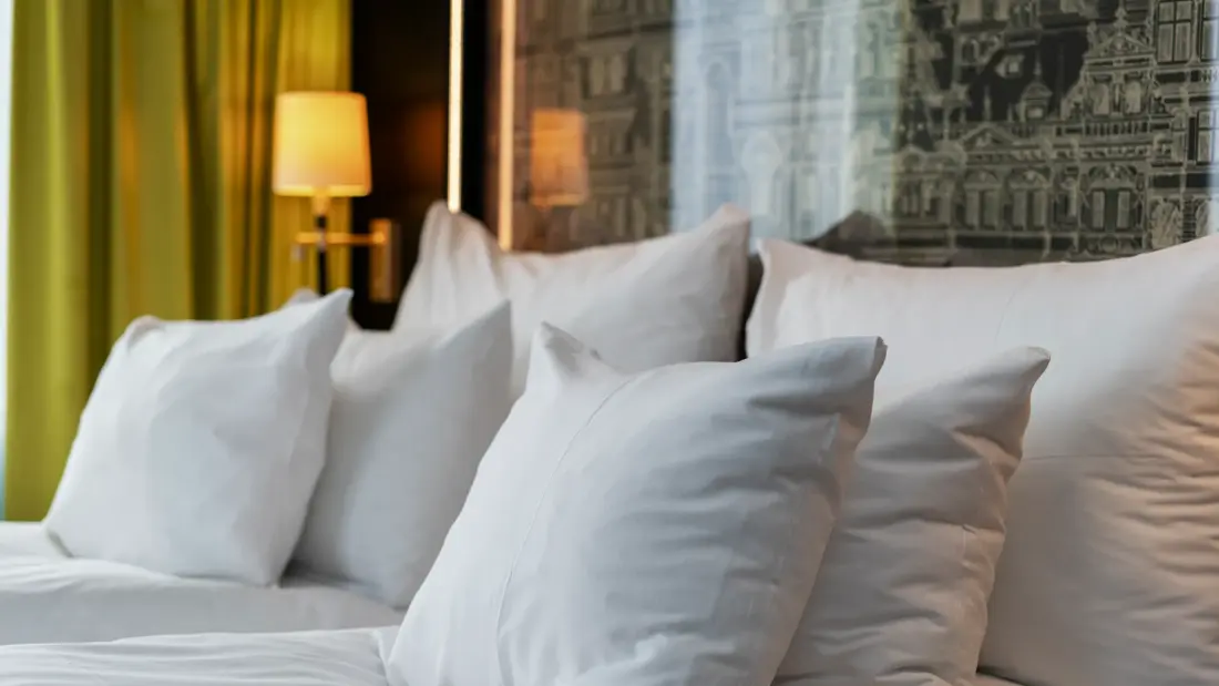 Business rom med dobbeltseng, zoomet inn på hvite puter.