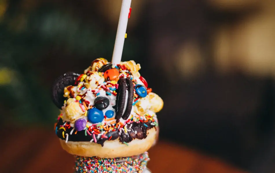 Mexico, Queretaro, Queretaro - April 4, 2018: Chocolate donut milkshake with lots of toppings, sprinkles, popcorn, cookies and cream standing on a wooden table