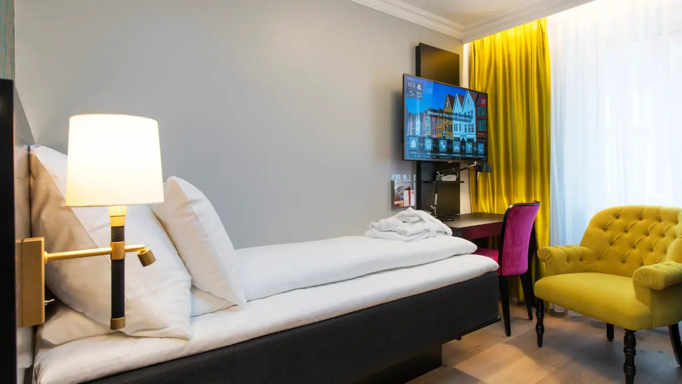 Seng, lenestol og pult på Standard Singel Rum på Thon Hotel Rosenkrantz Bergen 