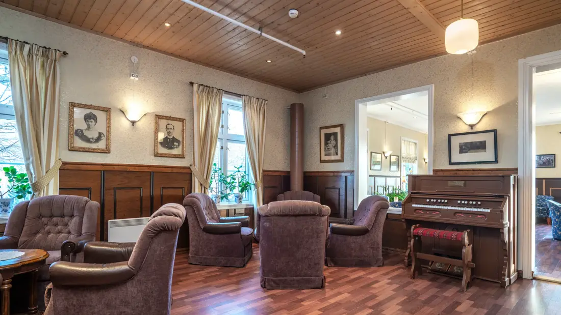 Gode, dype stoler i loungen med piano i bakgrunnen