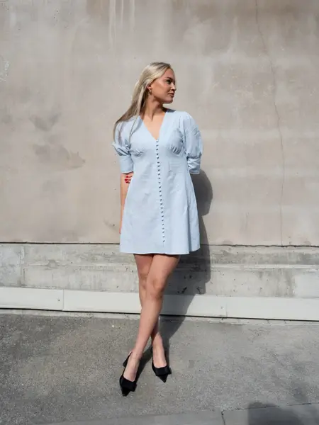 Ung dame i lyseblå linkjole og sorte pumps