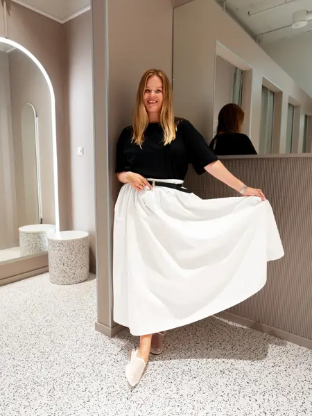 Damemodell med sort topp og hvitt langt skjørt