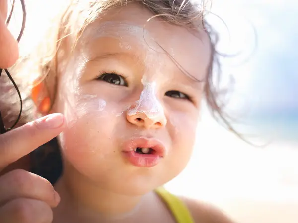 Jente med solkrem i ansiktet