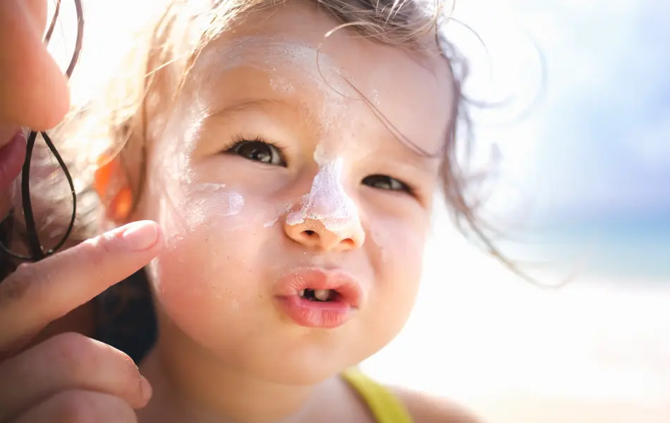Jente med solkrem i ansiktet