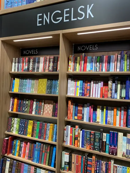 Norli med eikebokhyller fra gulv til tak fylt med bøker i ulike sjangre