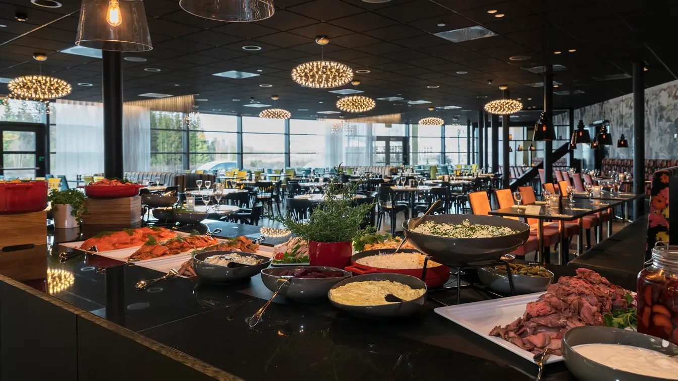 Buffetbord med mat og restauranten i bakgrunnen på Brasseri Bassit på Thon Hotel Oslo Airport