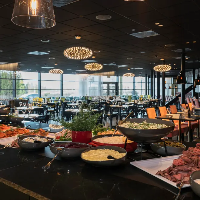 Buffetbord med mat og restauranten i bakgrunnen på Brasseri Bassit på Thon Hotel Oslo Airport