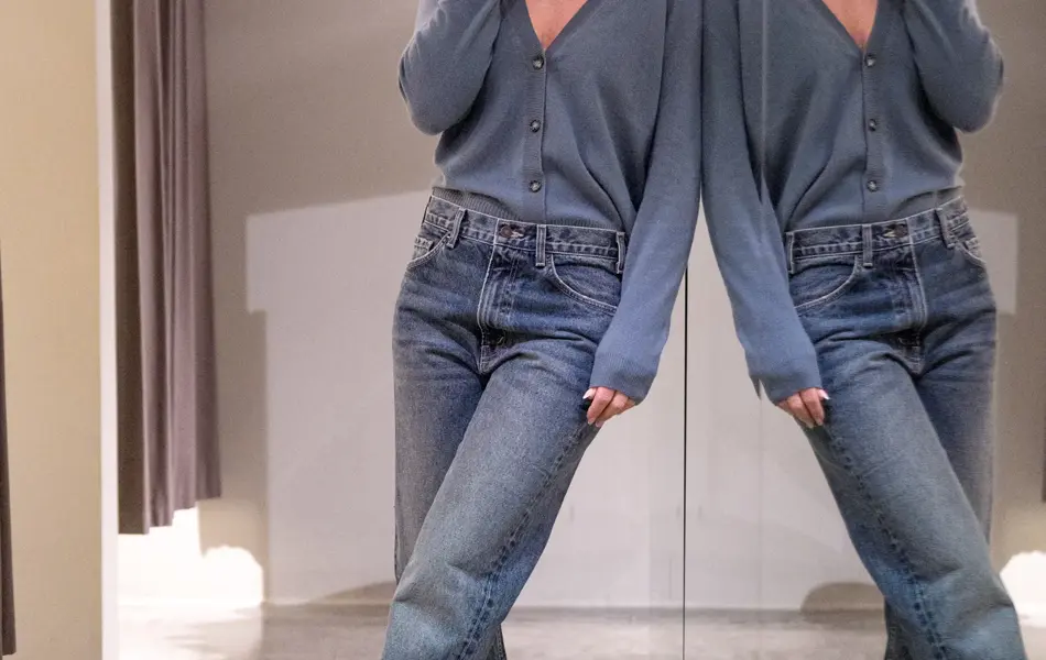 Dame i dueblå cardigan, jeans og sorte sko