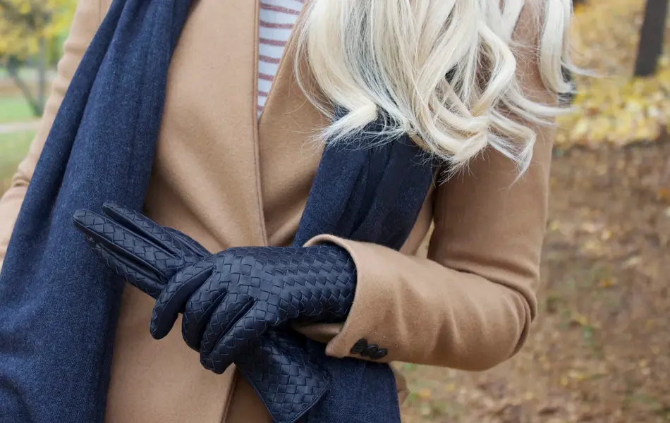 Dame har på seg kåpe og har tatt av seg en hanske