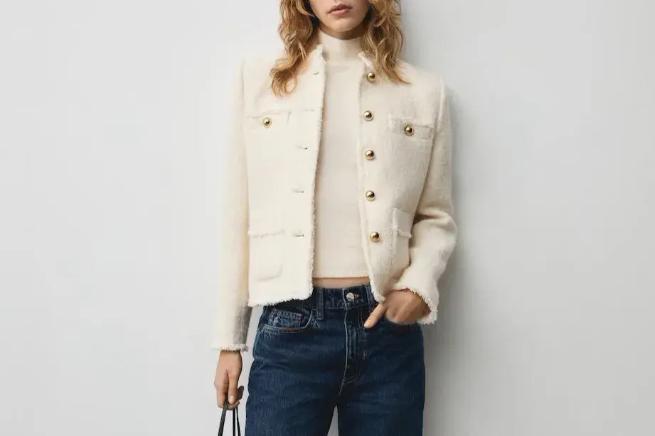 Dame med hvit boucleblazer og jeans