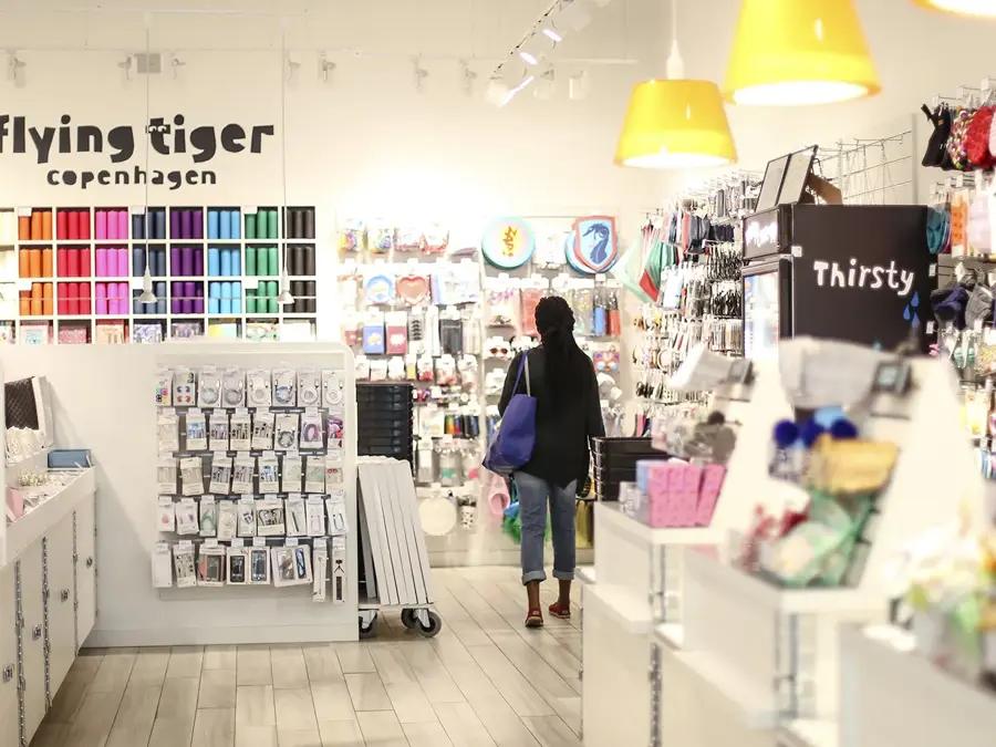 En dame med veske som går gjennom butikken til Flying Tiger Copenhagen