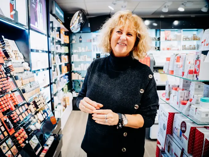 ansatt viser frem ulike sminkeprodukter