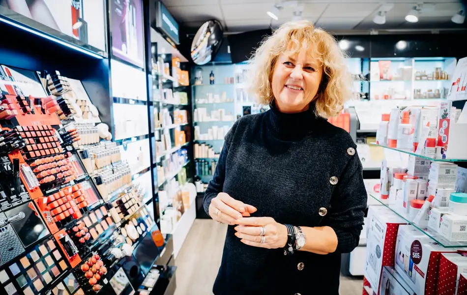 ansatt viser frem ulike sminkeprodukter